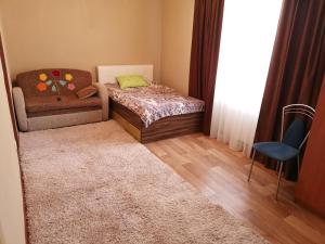 a small bedroom with a bed and a chair at Центр г Норильска Ленинский 24 in Noril'sk