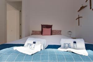 a bedroom with a bed with two pillows on it at APOSENTUS - The light house at Miragaia in Porto