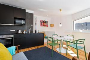 a kitchen and living room with a table and chairs at APOSENTUS - The light house at Miragaia in Porto