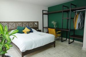 a bedroom with a bed and a green wall at The Dear in Puebla