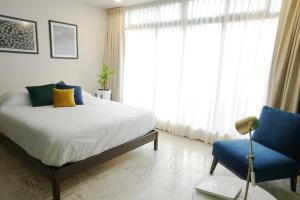 a bedroom with a bed and a blue chair at The Dear in Puebla