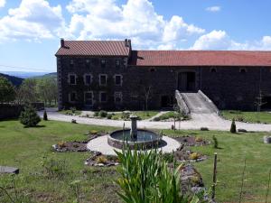 a building with a fountain in the middle of a yard at Suite romantique privative en pleine nature Au chant de l'eau in Siaugues Ste Marie