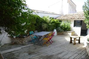 a wooden deck with a table and chairs on it at Magnifique rétaise-hyper centre le Bois-Plage-en-Ré in Le Bois-Plage-en-Ré