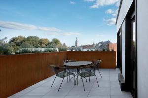 eine Terrasse mit einem Tisch und Stühlen auf dem Balkon in der Unterkunft Alpha Hotel and Aparthotel in Tienen