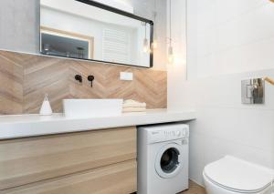 a bathroom with a washing machine under a sink at Sailor 7 Z bocznym widokiem na morze in Ustronie Morskie +21 photos