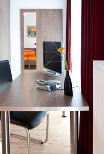 a table with a phone and a laptop on it at Hotel Merlin in Filderstadt