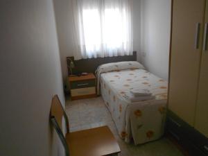a small bedroom with a bed and a window at Hostal Ca La Irene in San Vicente de Castellet