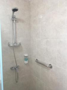 y baño con cabina de ducha con cabezal de ducha. en Hostal Loreto Belen en Puerto Natales