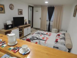 ein Wohnzimmer mit einem Bett und einem Tisch mit einem sidx sidx in der Unterkunft APARTMAN AZRA in Sarajevo