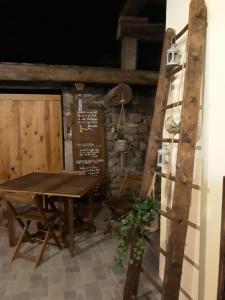 een eetkamer met een tafel en een ladder bij Suite privative sur Domaine Au chant de l'eau avec possibilité séjour bien-être in Siaugues Ste Marie