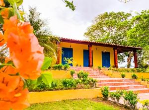 a yellow house with blue doors and stairs at Finca Pamel in Los Santos