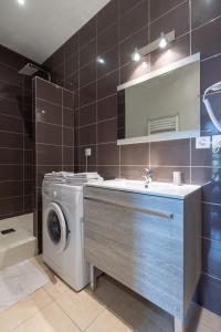 a bathroom with a washing machine and a sink at Legend- Parking privé Gratuit- Terrasse privée- Wifi - Convert - Alimentec in Bourg-en-Bresse