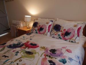 a bed with a floral bedspread and pillows on it at Cocklekitty Cottage in Kelso