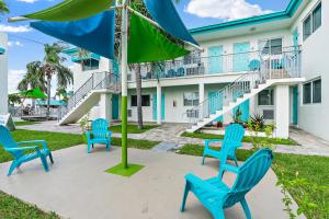 a group of chairs and an umbrella in front of a building at Hollywood Beachside Boutique Suite in Hollywood