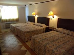 a hotel room with two beds and a window at Hotel Acuario de Veracruz in Veracruz
