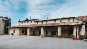 a large white building with a large driveway at AGRITURISMO LE ZORLESCHE in Camisano