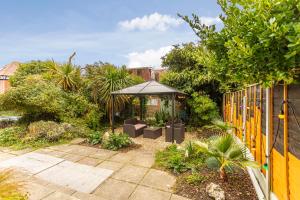 einen Garten mit einem Sonnenschirm und einem Zaun in der Unterkunft The Ravensbourne Hotel in Bournemouth