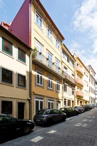a row of buildings on a street with parked cars at Estrela de Gaia Apartments in Vila Nova de Gaia