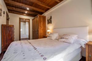 a bedroom with a large white bed with wooden ceilings at GERBER de Alma de Nieve in Baqueira-Beret
