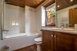 a bathroom with a tub and a toilet and a sink at GERBER de Alma de Nieve in Baqueira-Beret