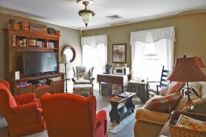a living room with a tv and chairs at Strasburg Village Inn in Strasburg