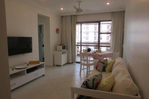 un soggiorno con divano, TV e tavolo di Apto de 2 quartos e 2 banheiros sociais no Barramares a Rio de Janeiro