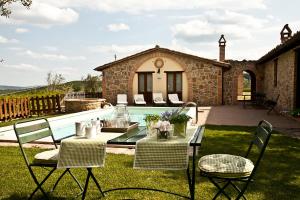un patio con mesa, sillas y piscina en Agriturismo Ripaiani, en Marsciano