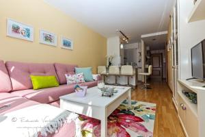 salon z różową kanapą i stołem w obiekcie Noia Compostellae Beach w mieście Portosin