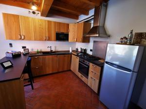 - une cuisine avec des placards en bois et un réfrigérateur blanc dans l'établissement La Maison di Ale, à Pieve di Cento
