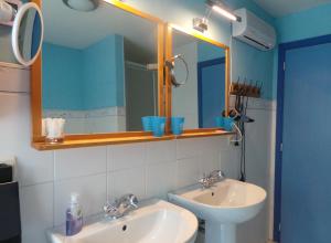 Baño con 2 lavabos y espejo en Villa De Ruiter, en Waasmunster