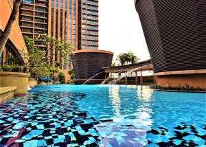 a pool with blue water in a city with tall buildings at Robinsons Apartments at Times Square KL in Kuala Lumpur