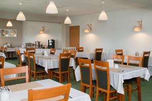 a dining room with tables and chairs with white tablecloths at Hotel U Zygmuntów in Leżajsk