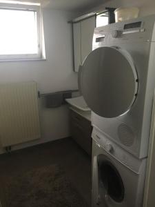 a washing machine in a small room with a window at L&L Lodge Günding in Günding