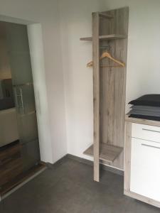 a kitchen with a wooden shelf and a refrigerator at L&L Lodge Günding in Günding