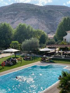 una piscina con una montaña en el fondo en Hotel Spa Elia, en Alcalá del Júcar