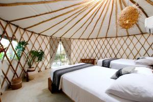 een slaapkamer met 2 bedden in een yurt bij Huaya Camp in Tulum