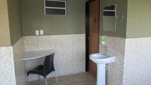 a bathroom with a toilet, sink and mirror at Resort Hotel Atlantic City Nautico Club in Teresina