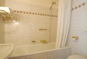 y baño con bañera, aseo y lavamanos. en Ristorante Napoleone, en Altheim