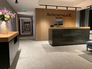 a lobby of an apartment building with a vase of flowers at Astrum Palace in Mažeikiai