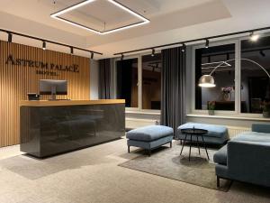 a lobby with a fireplace and a table and chairs at Astrum Palace in Mažeikiai