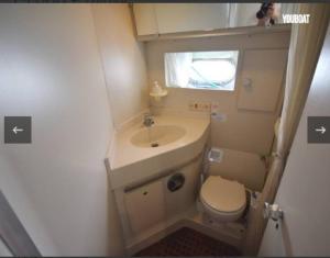 mała łazienka z umywalką i toaletą w obiekcie Beautiful Kiwi Boat w Barcelonie