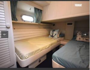 a small room with two beds and a window at Beautiful Kiwi Boat in Barcelona