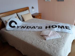 um quarto com uma cama com uma placa de casa aannis em Cynda´s home em Viseu