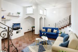 salon z niebieskimi kanapami i telewizorem w obiekcie Villa D'Esposito - Sorrento Coast w mieście Sant'Agnello