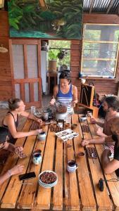 un groupe de personnes assises autour d'une table en bois dans l'établissement Utopia Eco Hotel, à Lanquín