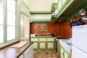 a kitchen with green cabinets and red tiles at Teatro Suites Málaga in Málaga