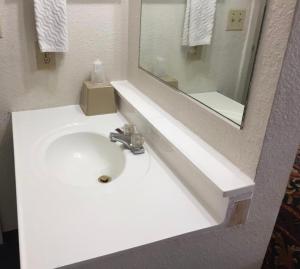 a white sink in a bathroom with a mirror at National 9 Inn Sand Canyon in Cortez