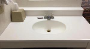 a white bathroom sink with a soap dispenser next to it at National 9 Inn Sand Canyon in Cortez