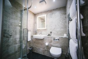 een badkamer met een douche, een toilet en een wastafel bij Bedford Hotel in Sidmouth