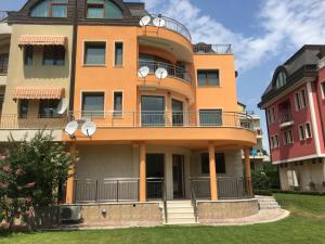 un grand bâtiment orange avec un balcon. dans l'établissement Villa Excelsior, à Saints Constantine et Helena